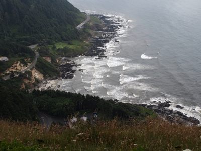 [At low tide triangular shaped waves approach the irregular shaped shoreline.]